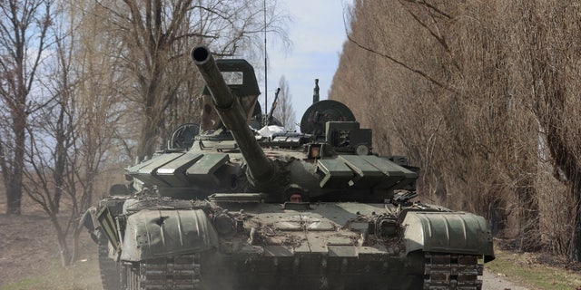 A Ukrainian service member drives a captured Russian T-72 tank, as Russia's attack on Ukraine continues, in the recently liberated village of Lukianivka, in Kyiv region, Ukraine March 27, 2022.  REUTERS/Serhii Nuzhnenko