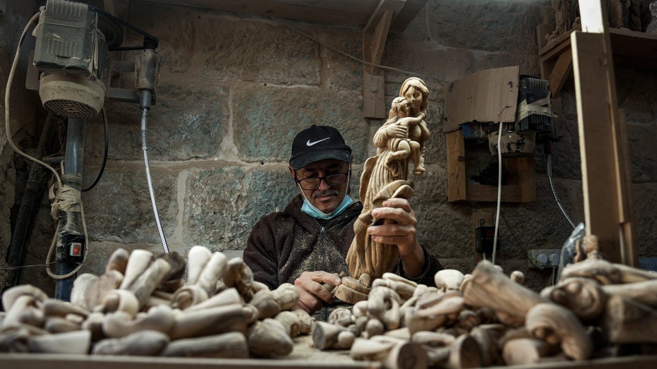 Palestinian man carves figurine of Virgin Mary and baby Jesus