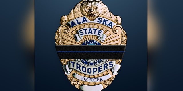 A thin blue line is seen around an Alaska State Troopers badge as the agency mourns the loss of Court Services Officer Curtis Worland.