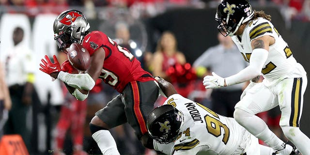 Rachaad White, #29 of the Tampa Bay Buccaneers, fumbles the ball against Cameron Jordan, #94 of the New Orleans Saints, during the third quarter in the game at Raymond James Stadium on Dec. 5, 2022 in Tampa, Florida.