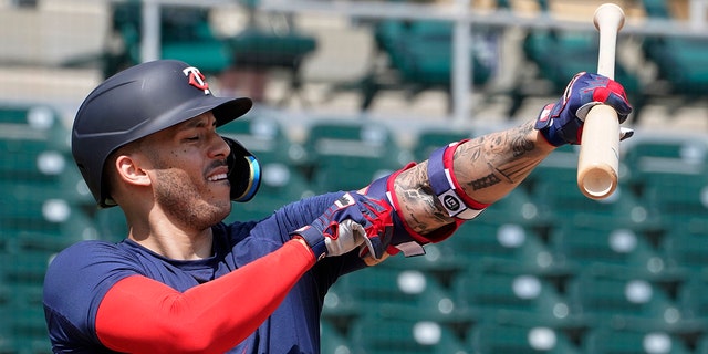 Minnesota Twins' Carlos Correa adjusts his arm protector during batting practice at Hammond Stadium Wednesday March 23, 2022, in Fort Myers, Fla. 