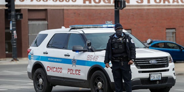 A Chicago Police officer monitors the scene after a shooting in Chicago, Illinois, on March 14, 2021. - At least 15 people were shot, two of them fatally, after gunfire broke out at a South Chicago business where a party was being held early on March 14, 2021.