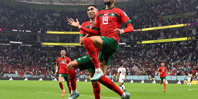 Morocco's forward #19 Youssef En-Nesyri (R) celebrates with Morocco's defender #02 Achraf Hakimi after scoring the opening goal during the Qatar 2022 World Cup quarter-final football match between Morocco and Portugal at the Al-Thumama Stadium in Doha on December 10, 2022. 