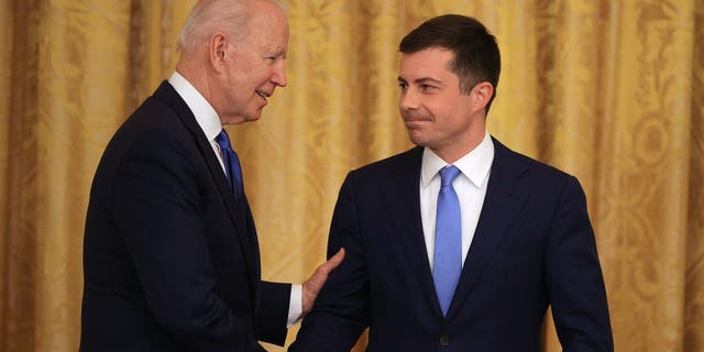 President Biden, left, shakes hands with Buttigieg during an event at the White House on June 25, 2021.