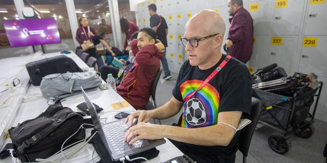 Journalist Grant Wahl (right) works in the FIFA Media Center before a FIFA World Cup Qatar 2022 Group B match between Wales and the United States at Ahmad Bin Ali Stadium on Nov. 21, 2022 in Al Rayyan, Qatar. He had been detained earlier by stadium security for wearing a rainbow-colored T-shirt before later being allowed to enter the stadium.