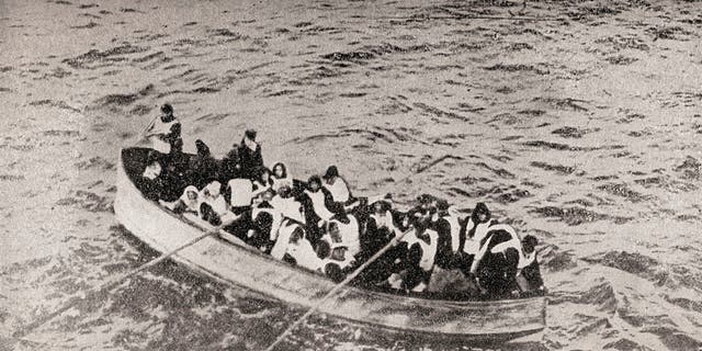 Survivors of The Rms Titanic in one of her collapsible lifeboats, just before being picked up by The Carpathia. Woman share in the rowing. 