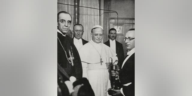 Pope Pius XI (1857-1939), center, on the Vatican radio station's inauguration, along with inventor Guglielmo Marconi (1874-1937), Feb. 1931, Vatican City. 