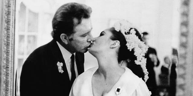 Elizabeth Taylor and Richard Burton kiss at their first wedding in Montreal, Canada. They married twice, but both marriages ended in divorce.