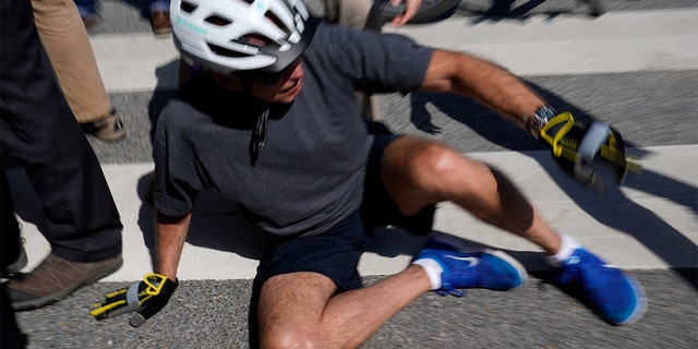 President Biden falls to the ground after riding up to members of the public during a bike ride in Rehoboth Beach, Delaware, June 18, 2022. REUTERS/Elizabeth Frantz