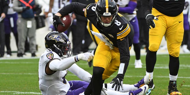 Pittsburgh Steelers quarterback Kenny Pickett (8) slips out of the grasp of Baltimore Ravens linebacker Patrick Queen (6) during the first half of an NFL football game in Pittsburgh, Sunday, Dec. 11, 2022. 
