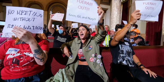 People hold signs and shout slogans as they protest before the cancellation of the Los Angeles City Council meeting on Oct. 12, 2022 in Los Angeles.