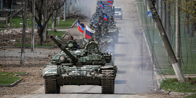 A convoy of pro-Russian troops moves along a road in Mariupol, Ukraine, April 21, 2022.