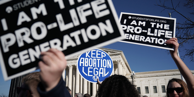 Pro-life activists try to block the sign of a pro-choice activist during the 2018 March for Life January 19, 2018, in Washington, DC. A