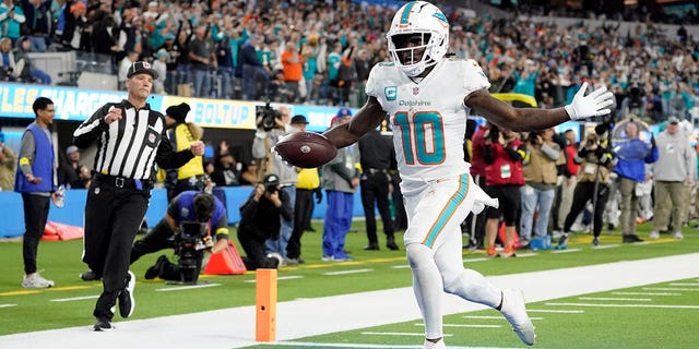 Miami Dolphins wide receiver Tyreek Hill (10) scores a touchdown after recovering a fumble during the first half of an NFL football game against the Los Angeles Chargers Sunday, Dec. 11, 2022, in Inglewood, Calif.