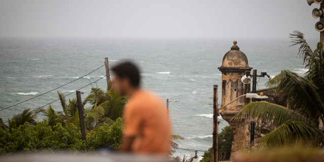 A man stands in front of a beach before the arrival of Hurricane Fiona in San Juan, Puerto Rico.